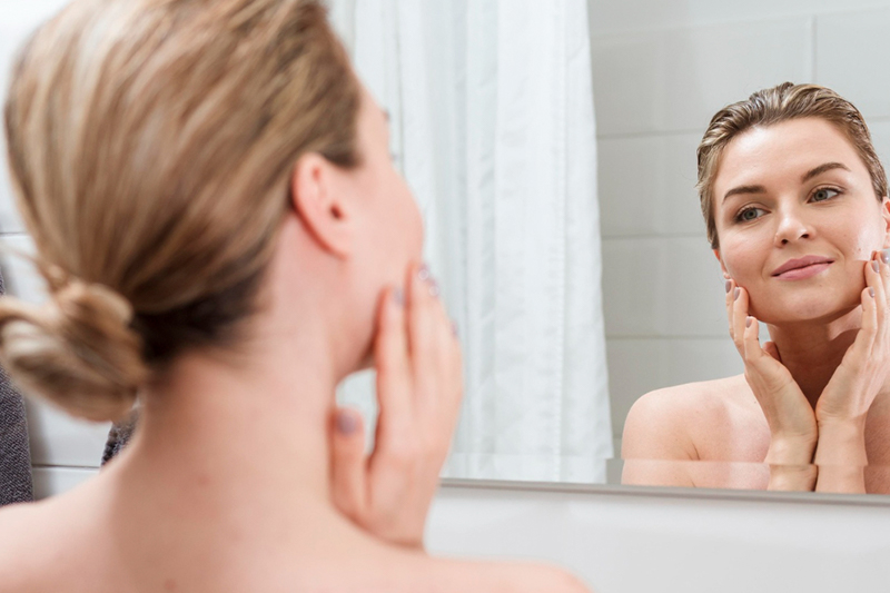 mujer se mira en el espejo feliz por los resultados