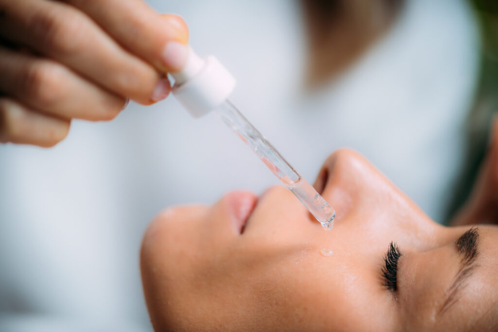 Cosmetician Applying Hyaluronic Acid Serum on Woman’s Face
