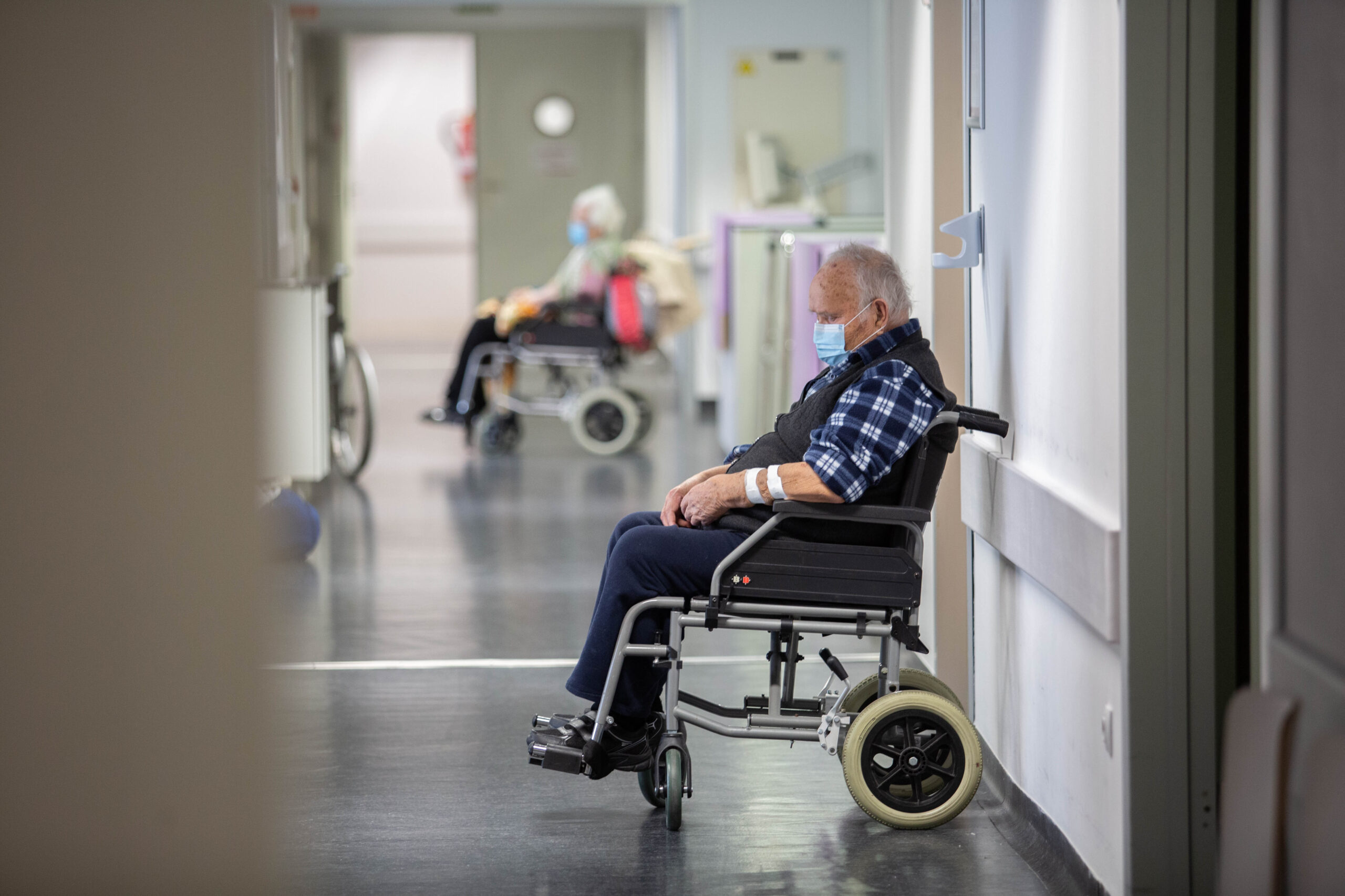 Dos-personas-mayores-esperan-en-un-hospital-Ribera